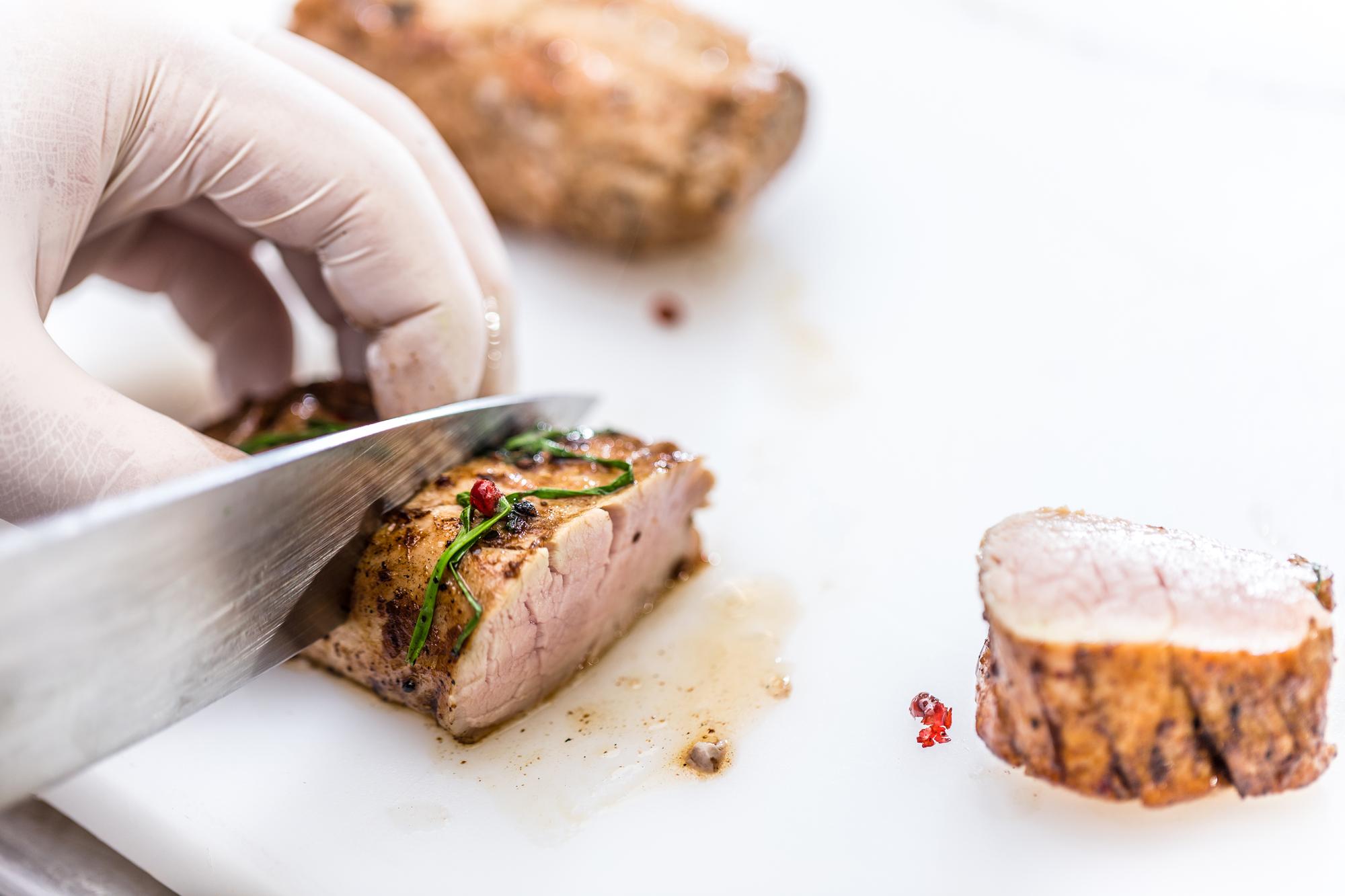Hands searing meat on hot pan workshop